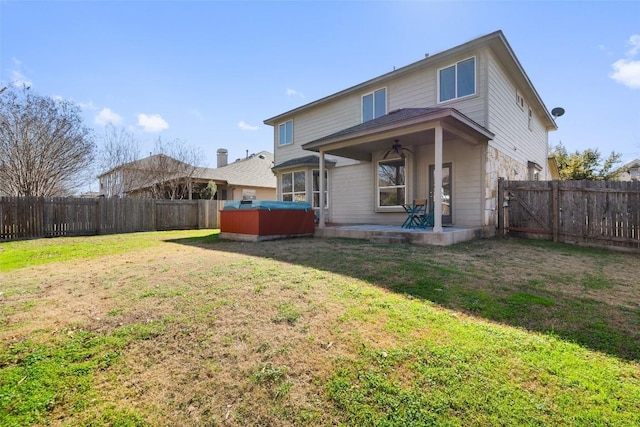 rear view of property featuring a patio, a lawn, ceiling fan, and a jacuzzi