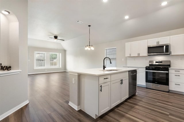 kitchen featuring stainless steel appliances, dark wood-style flooring, a sink, light countertops, and backsplash