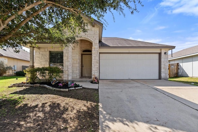 view of front of property featuring an attached garage, stone siding, driveway, and fence