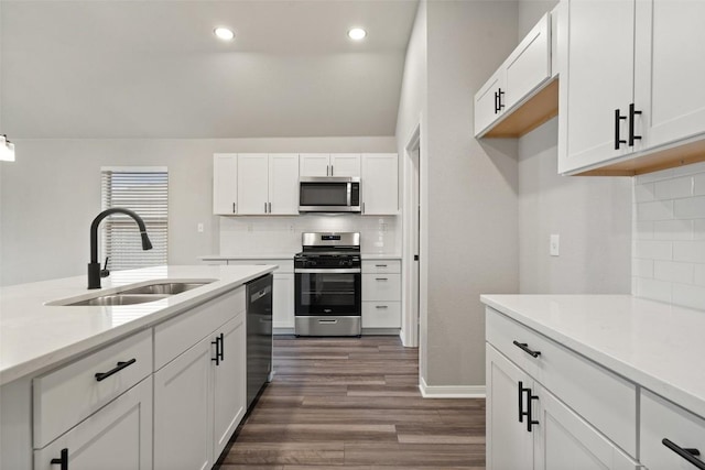 kitchen featuring sink, backsplash, stainless steel appliances, white cabinets, and dark hardwood / wood-style flooring