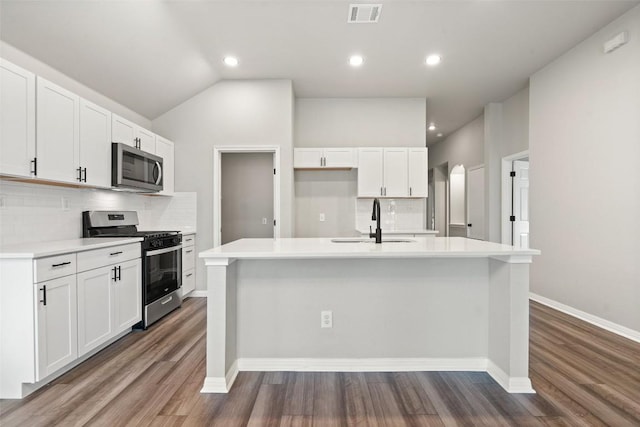 kitchen with stainless steel appliances, an island with sink, and white cabinets