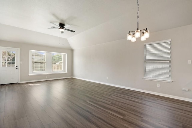 unfurnished living room with ceiling fan with notable chandelier, vaulted ceiling, and dark hardwood / wood-style floors