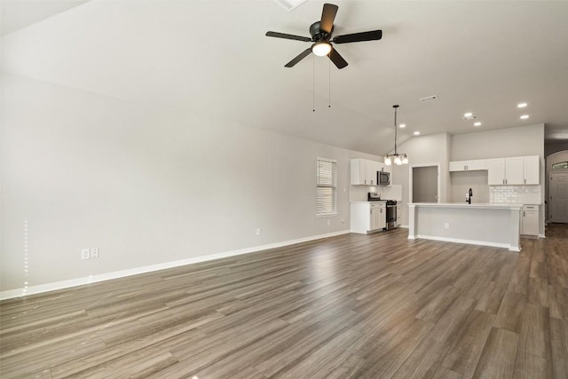 unfurnished living room with vaulted ceiling, sink, ceiling fan, and light hardwood / wood-style flooring