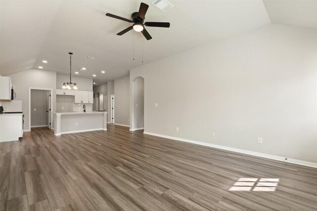 unfurnished living room featuring ceiling fan, lofted ceiling, and dark hardwood / wood-style flooring