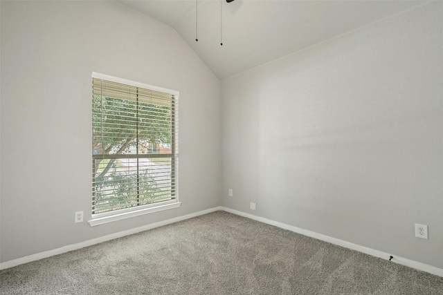 spare room with vaulted ceiling and carpet flooring