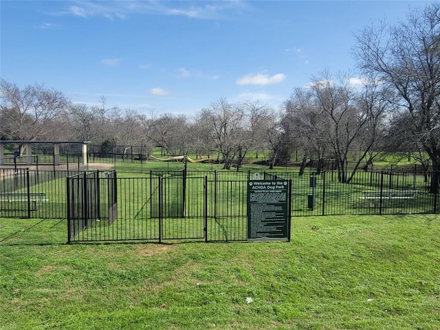 view of gate featuring fence and a lawn