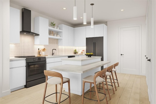 kitchen with pendant lighting, refrigerator, white cabinetry, black range with electric stovetop, and wall chimney exhaust hood