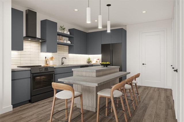 kitchen featuring decorative light fixtures, tasteful backsplash, black range with electric cooktop, wall chimney range hood, and light wood-type flooring