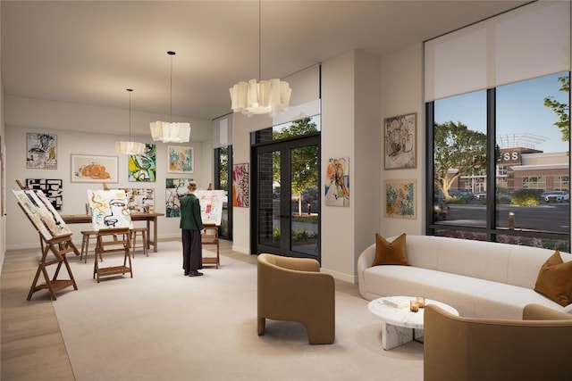 living room with plenty of natural light, light hardwood / wood-style floors, and french doors