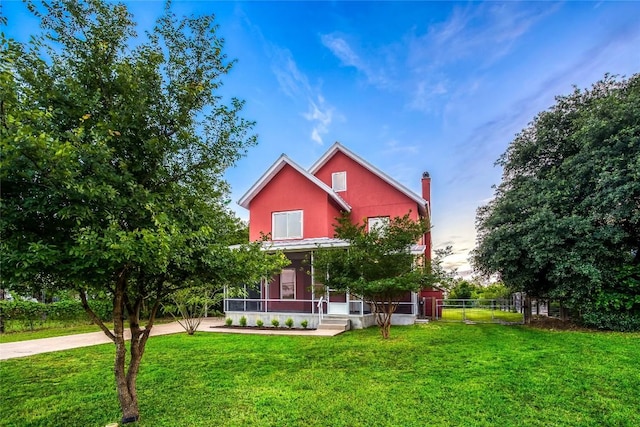 view of front of house with a sunroom and a front lawn