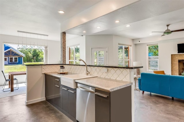 kitchen featuring a healthy amount of sunlight, sink, stainless steel dishwasher, and backsplash