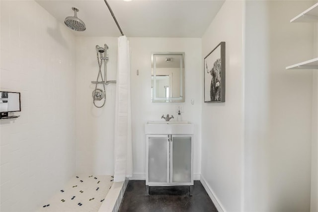 bathroom featuring a tile shower and vanity