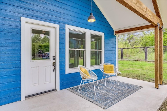 entrance to property with a patio area and a lawn