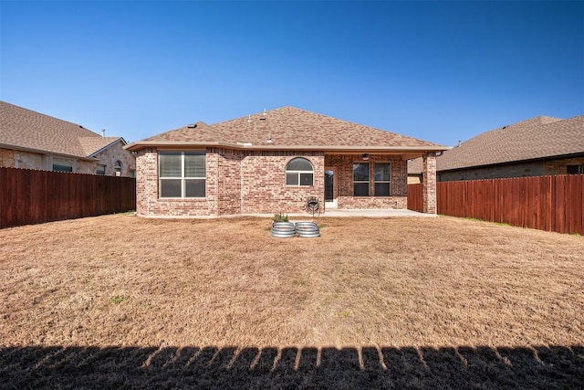 rear view of house featuring a yard and a patio