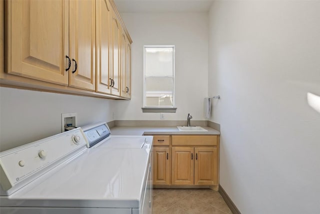 laundry area featuring cabinets, sink, light tile patterned floors, and washer and clothes dryer