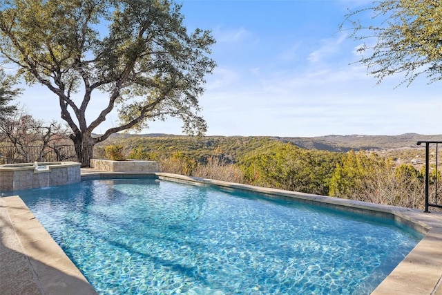 view of pool featuring an in ground hot tub and a mountain view