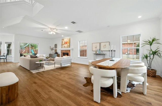 interior space with hardwood / wood-style flooring, a brick fireplace, and plenty of natural light