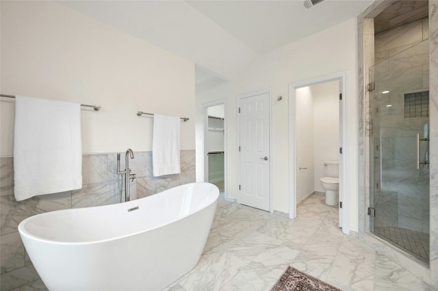 bathroom featuring tile walls, toilet, and separate shower and tub