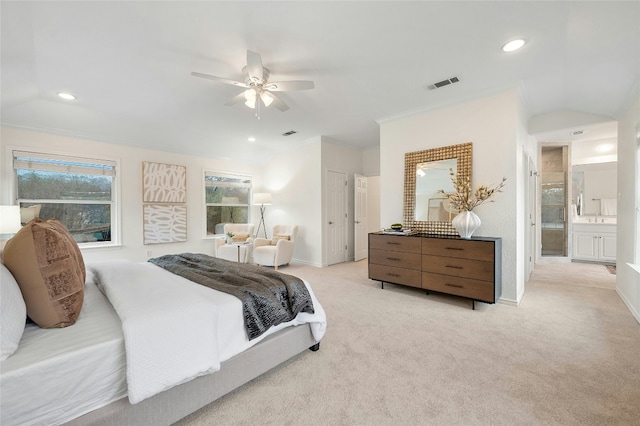 bedroom featuring ensuite bath, ornamental molding, light colored carpet, and ceiling fan