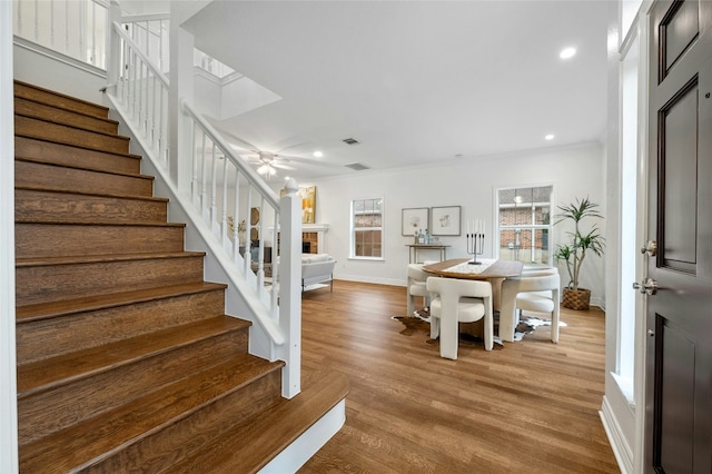 interior space featuring ceiling fan, ornamental molding, and light hardwood / wood-style flooring