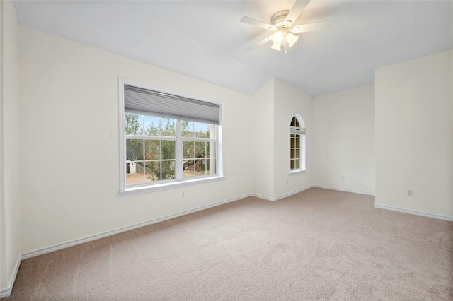 carpeted spare room featuring ceiling fan