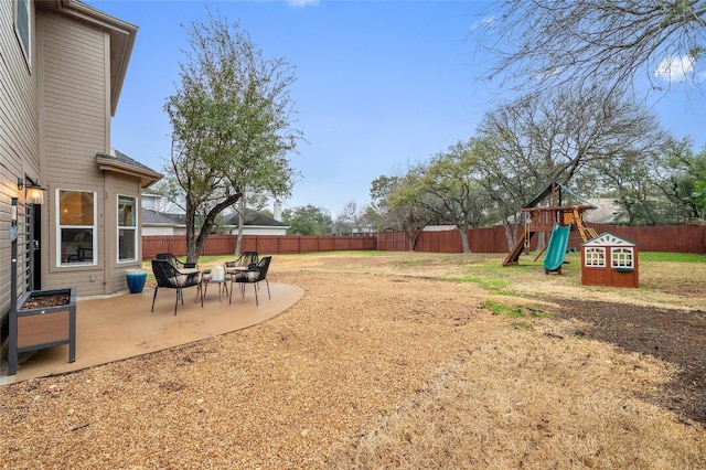 view of yard featuring a playground and a patio