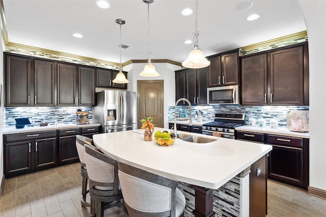 12332 Terraza Cir, Austin, TX 78726 - kitchen featuring stainless steel appliances, backsplash, a center island with sink, light countertops, and dark brown cabinetry