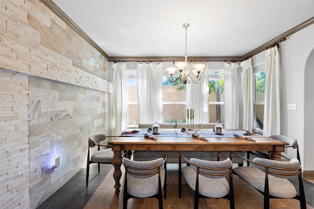 dining area with dark hardwood / wood-style flooring, ornamental molding, and an inviting chandelier