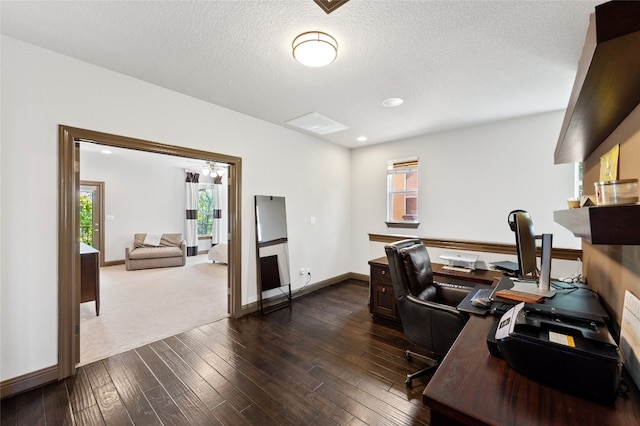 home office with a textured ceiling and dark hardwood / wood-style flooring