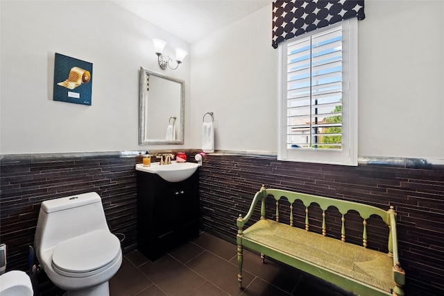 bathroom featuring toilet, a wainscoted wall, tile patterned flooring, and vanity