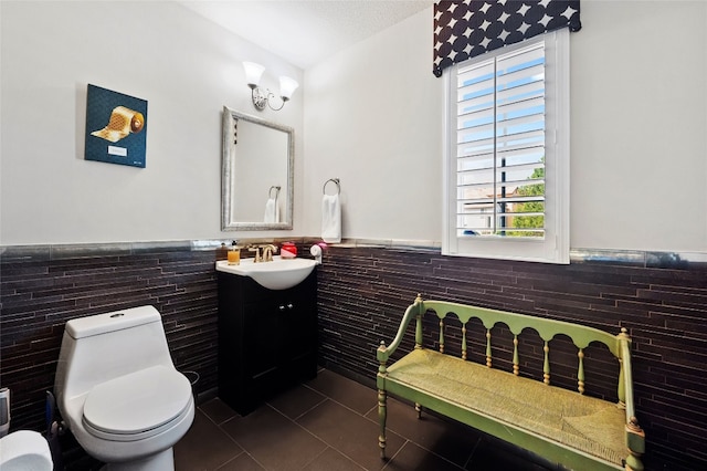12332 Terraza Cir, Austin, TX 78726 - half bath featuring tile walls, wainscoting, vanity, tile patterned flooring, and toilet