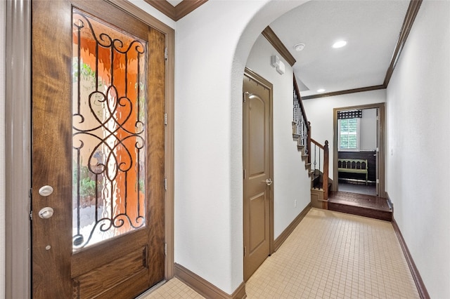 entrance foyer with arched walkways, crown molding, light tile patterned floors, baseboards, and stairs