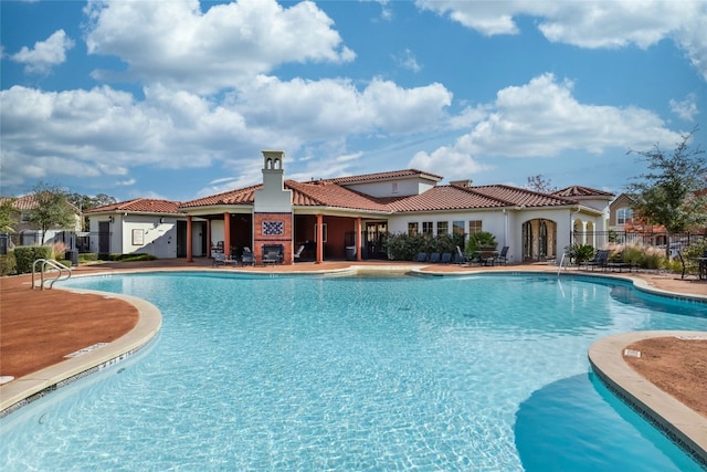 view of swimming pool featuring a fireplace and a patio area