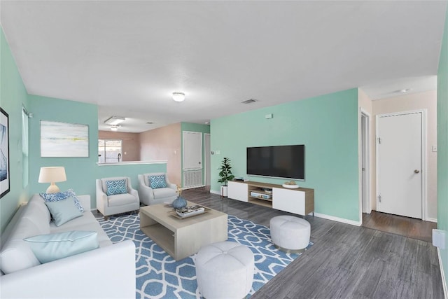 living area featuring wood finished floors, visible vents, and baseboards