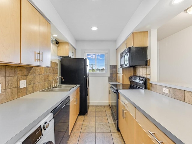 kitchen featuring light tile patterned floors, sink, tasteful backsplash, black appliances, and washer / clothes dryer