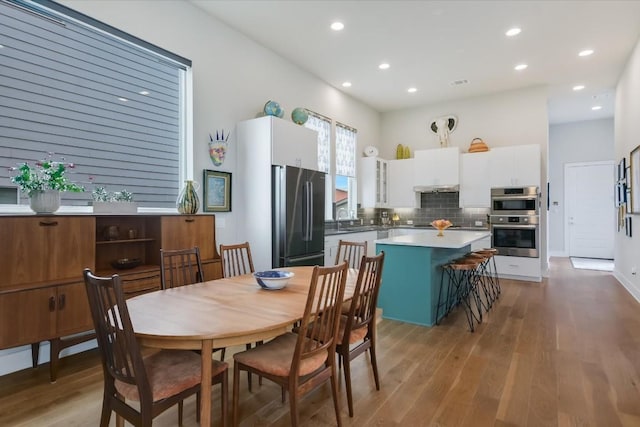 dining space with sink and light wood-type flooring