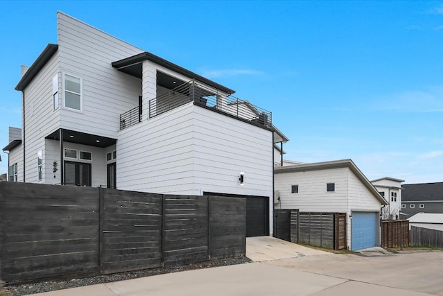 view of side of property featuring a garage and a balcony