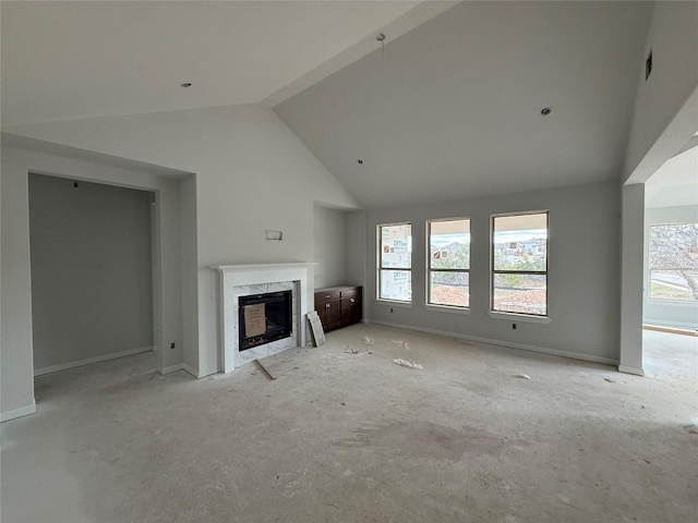 unfurnished living room featuring a fireplace and high vaulted ceiling