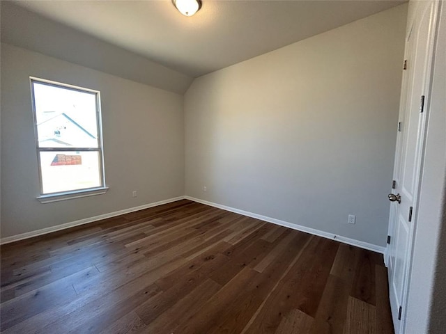 interior space featuring lofted ceiling, baseboards, and dark wood-type flooring