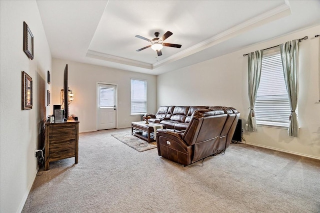 living room with ceiling fan, light colored carpet, and a raised ceiling