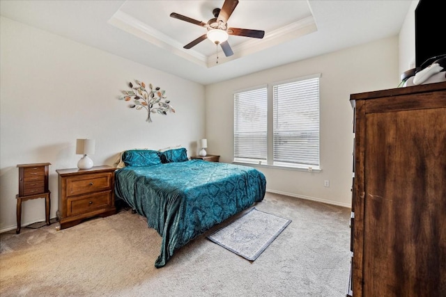 carpeted bedroom featuring ornamental molding, ceiling fan, and a tray ceiling