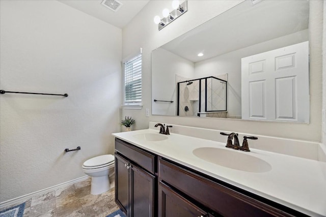 bathroom featuring toilet, vanity, and a shower with shower door