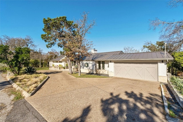 ranch-style house with stucco siding, concrete driveway, a standing seam roof, metal roof, and a garage