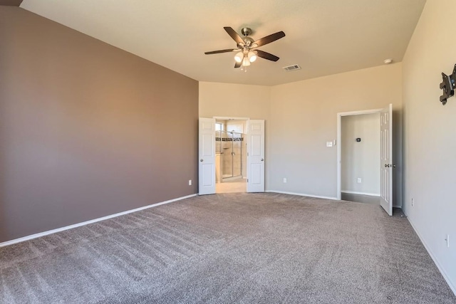 carpeted empty room featuring lofted ceiling, ceiling fan, visible vents, and baseboards