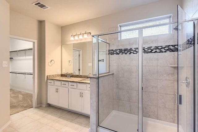 3264 Pablo Cir, Round Rock, TX 78665 - bathroom with a stall shower, double vanity, tile patterned flooring, and a walk in closet