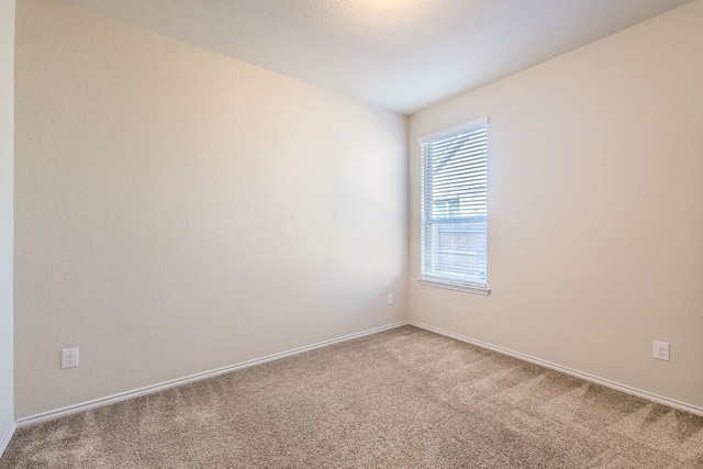 empty room featuring carpet flooring and baseboards