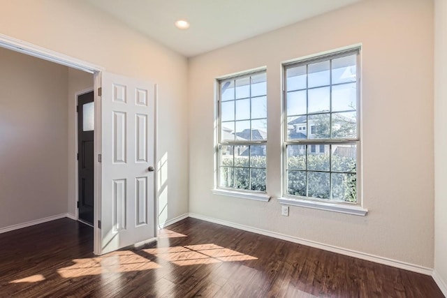 empty room featuring baseboards, dark wood finished floors, and recessed lighting