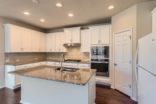 kitchen featuring under cabinet range hood, a kitchen island with sink, white cabinetry, and stainless steel appliances