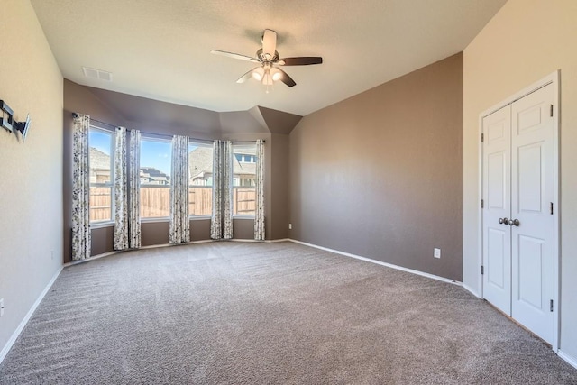 spare room featuring lofted ceiling, carpet flooring, and ceiling fan