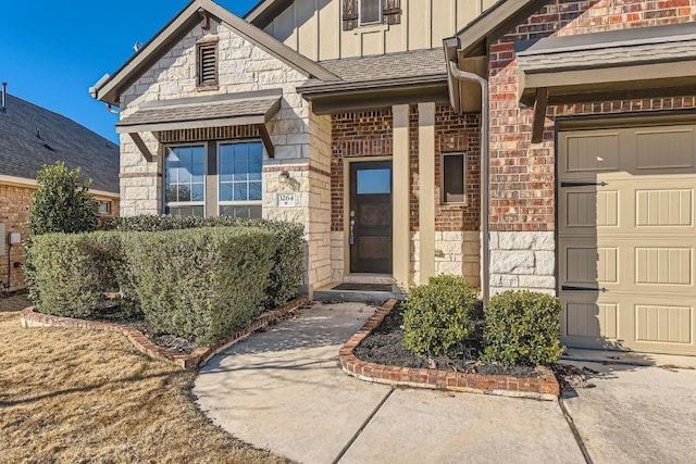 entrance to property featuring board and batten siding, stone siding, brick siding, and a garage